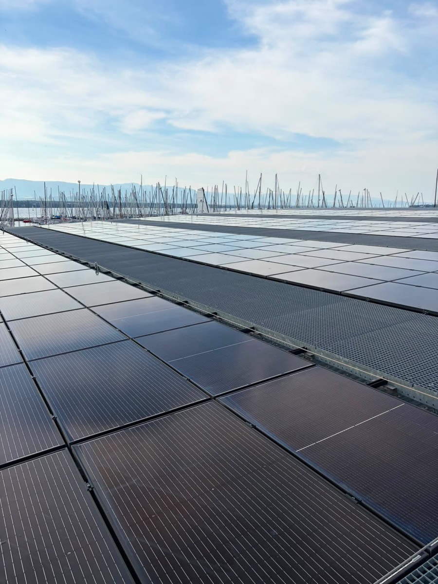 Toiture photovoltaïque au bord du lac Léman, bateaux d'un port de plaisance à droite