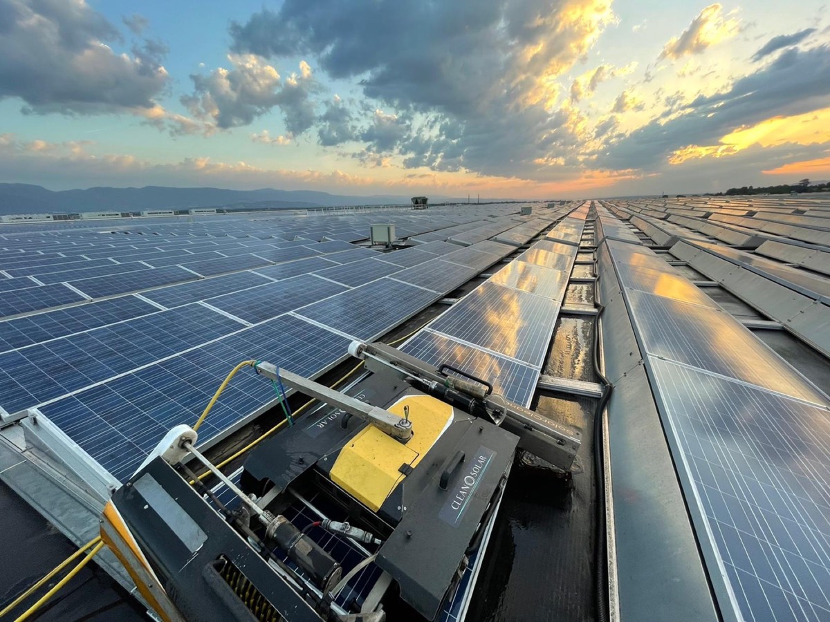 Robot de nettoyage sur une toiture photovoltaïque en fin de journée, lumière rasante